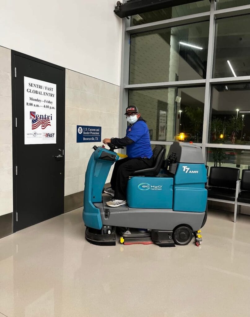 One Stop crew member on a ride-on floor scrubber