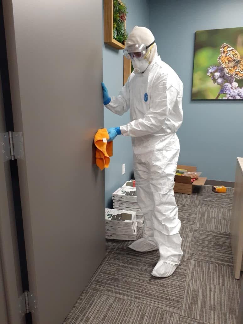 Staff in full protective gear cleaning a medical facility